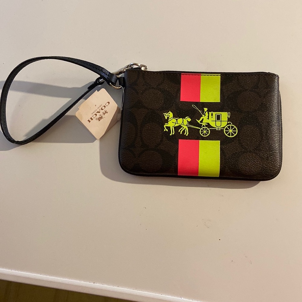Coach wristlet with a pink and green staged coach on a chocolate background